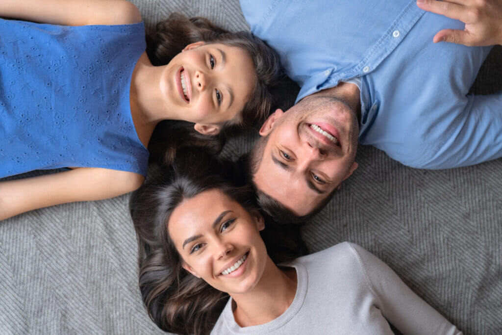 Familia migrante sonriendo a la cámara feliz por estar reunida gracias a que aprendieron como patrocinar a un familiar en estados unidos